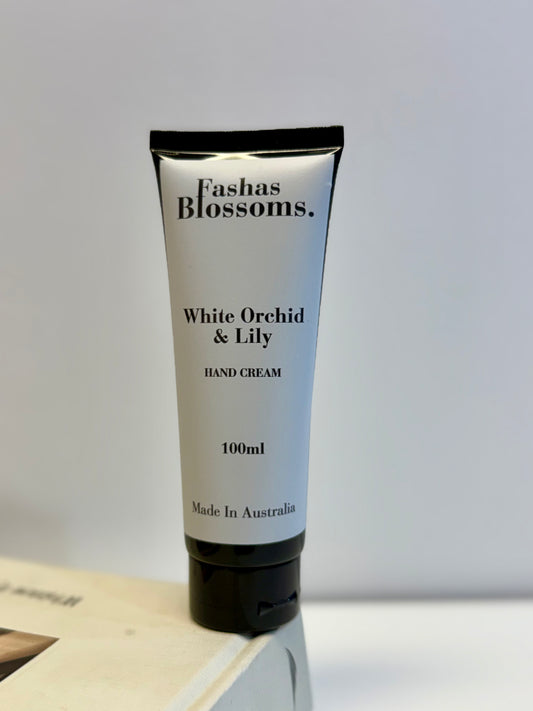 Hand cream tube labeled 'Fashas Blossoms White Orchid & Lily' on a light gray background