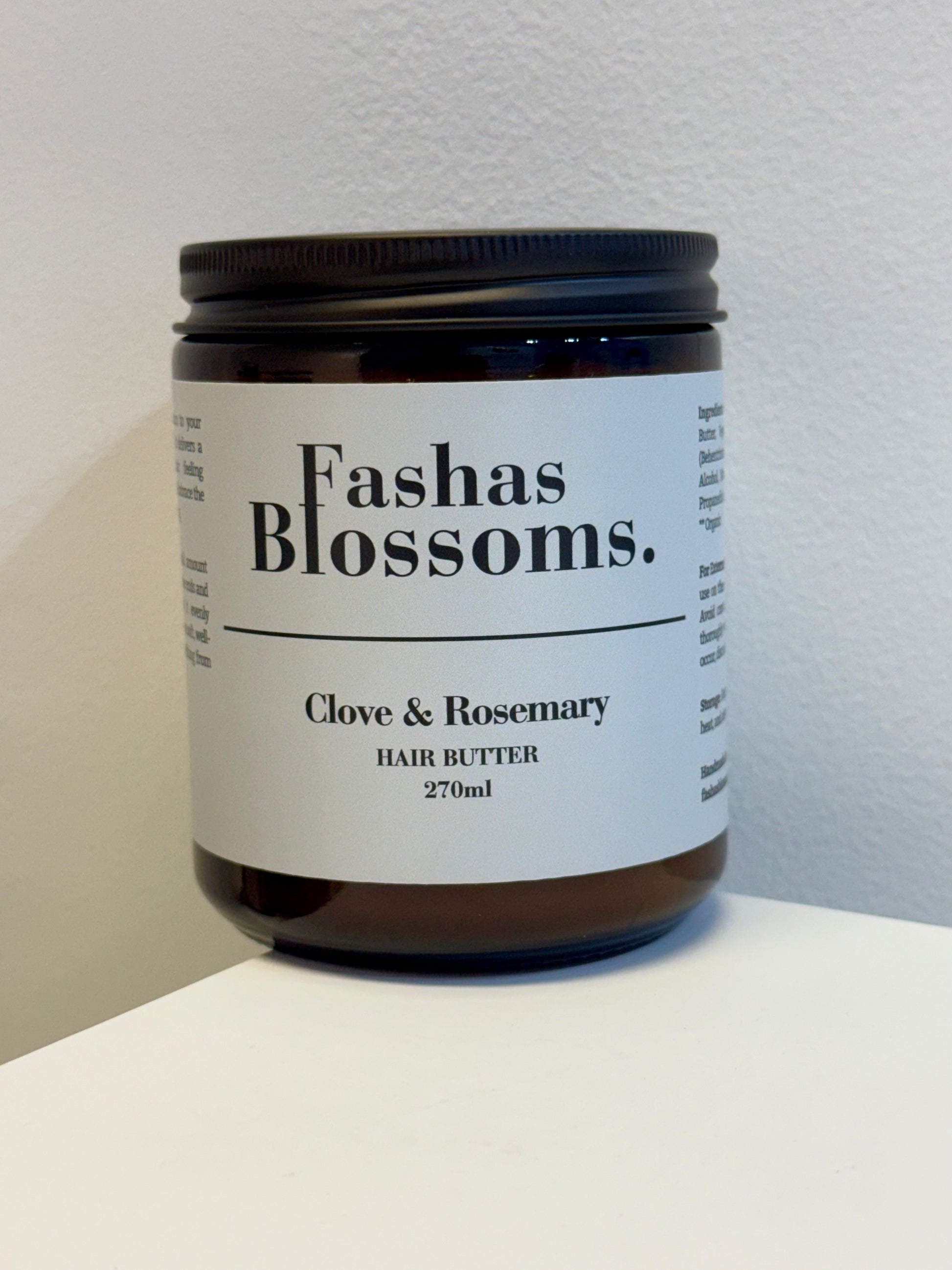 Jar of Fashas Blossoms Clove & Rosemary Hair Butter on a white surface with a light gray background