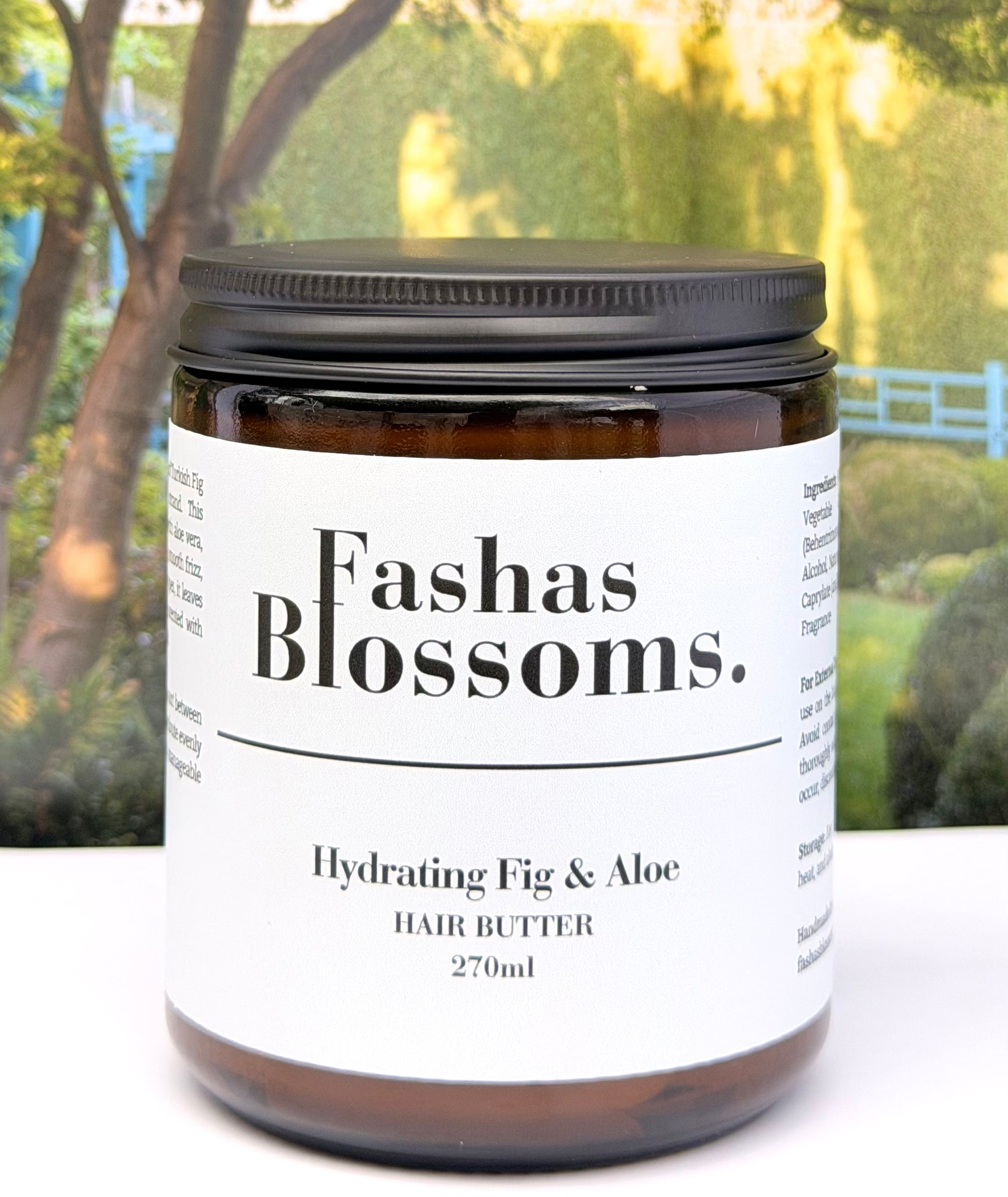 Jar of Fashas Blossoms hydrating fig & aloe hair butter with a blurred outdoor background