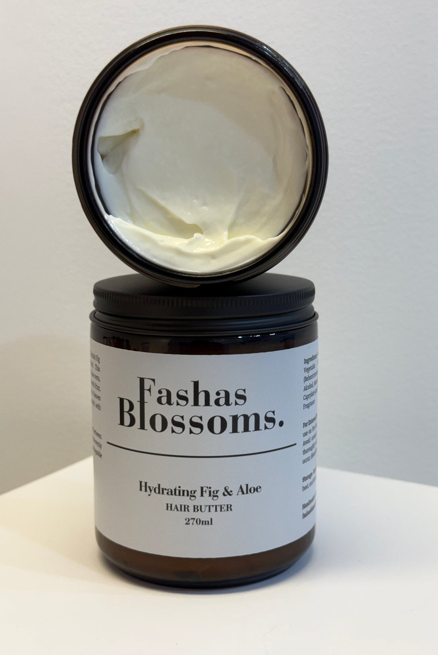 Jar of Fashas Blossoms hair butter with a black lid on a white background