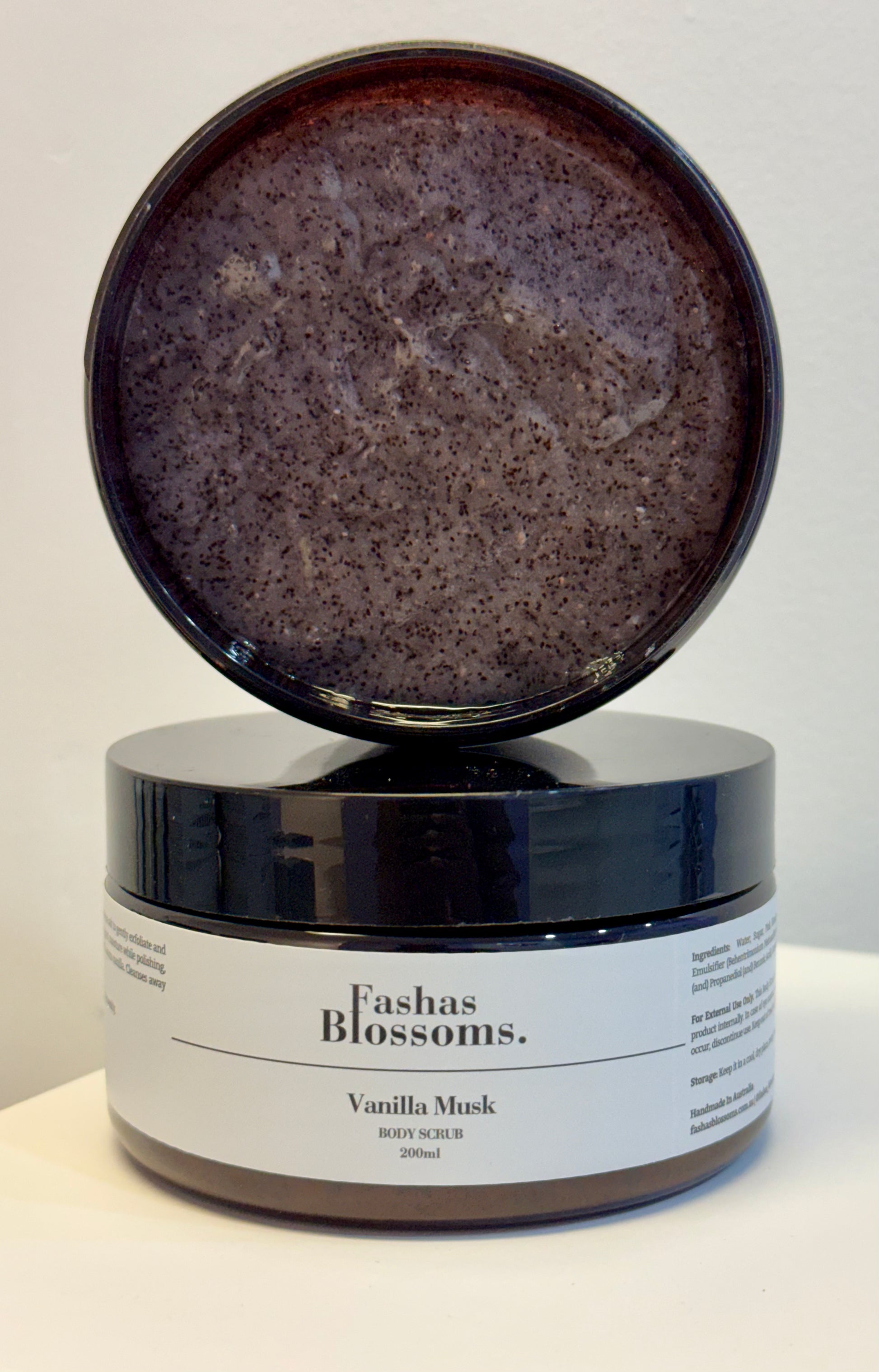 Jar of Fashas Blossoms Vanilla Musk body scrub with open lid on a white background